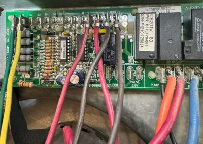 Close-up of a circuit board with multiple colored wires connected to terminals and electronic components.